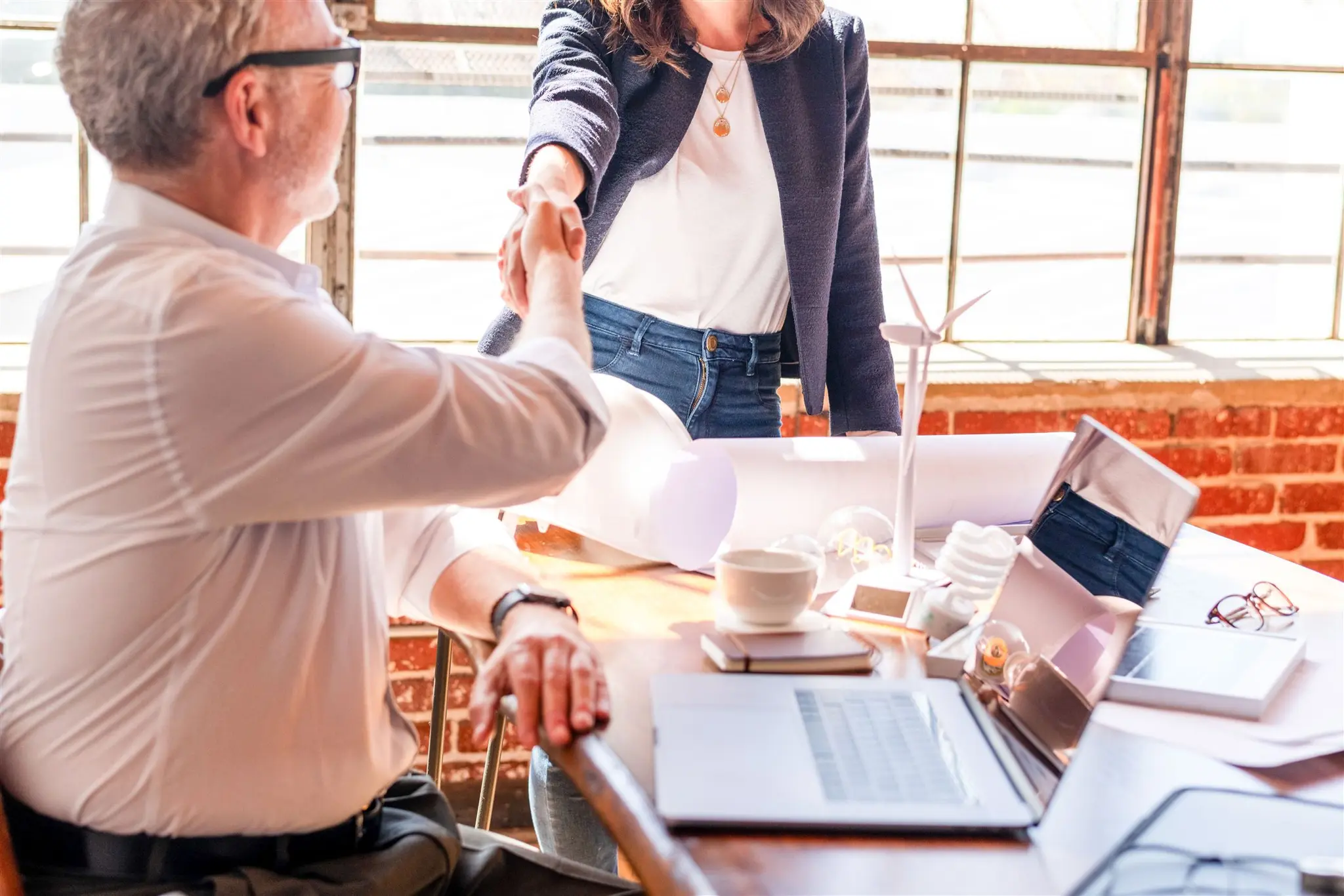 Two professionals shaking hands in a bright office